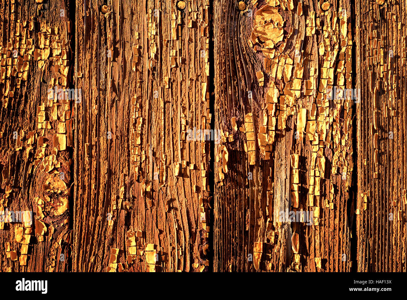 Sfald vernice su legno marrone con scaglie di pelatura e macchie di vernice vecchia. Peeling ruvida la superficie verniciata in colore di legno scuro. Foto Stock