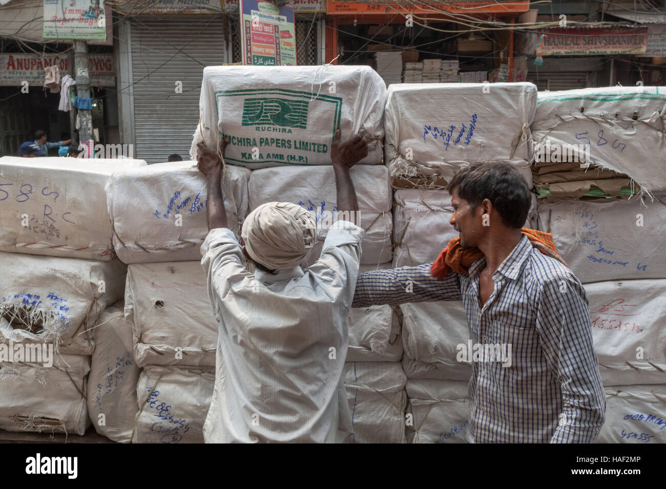 Gli uomini di carico merci confezionate (sconosciuto) su una carriola o del carro, Vecchia Delhi, India Foto Stock