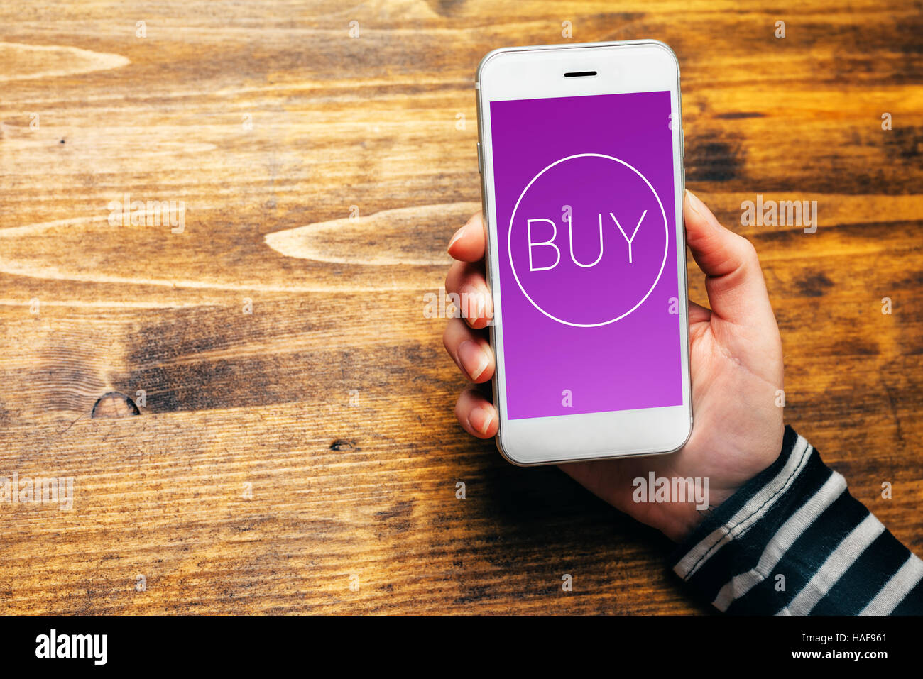 Utilizzando mobile wallet per acquistare articoli in shopping online, femmina mano azienda smartphone con icona di acquisto generato Foto Stock