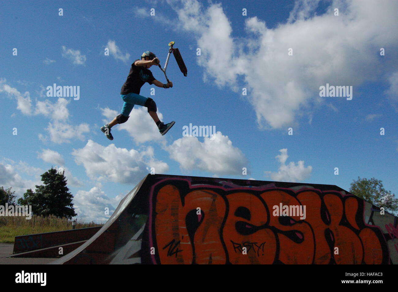 Scooter trick su una rampa, vasca da bagno Foto Stock
