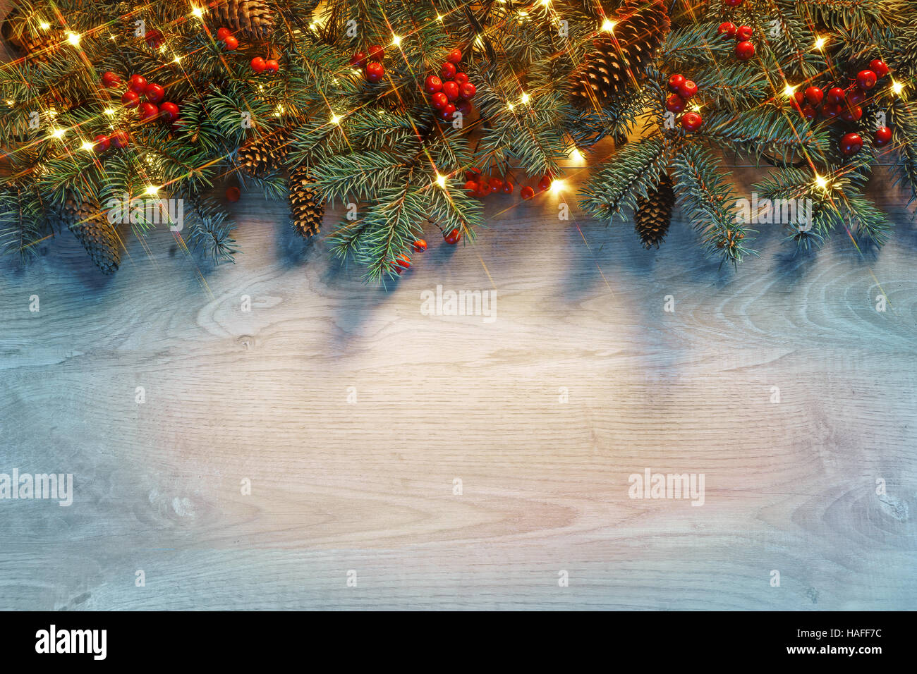 Natale abete con luci su sfondo di legno nel buio. Buon Natale e Felice Anno Nuovo!! Vista dall'alto. Foto Stock
