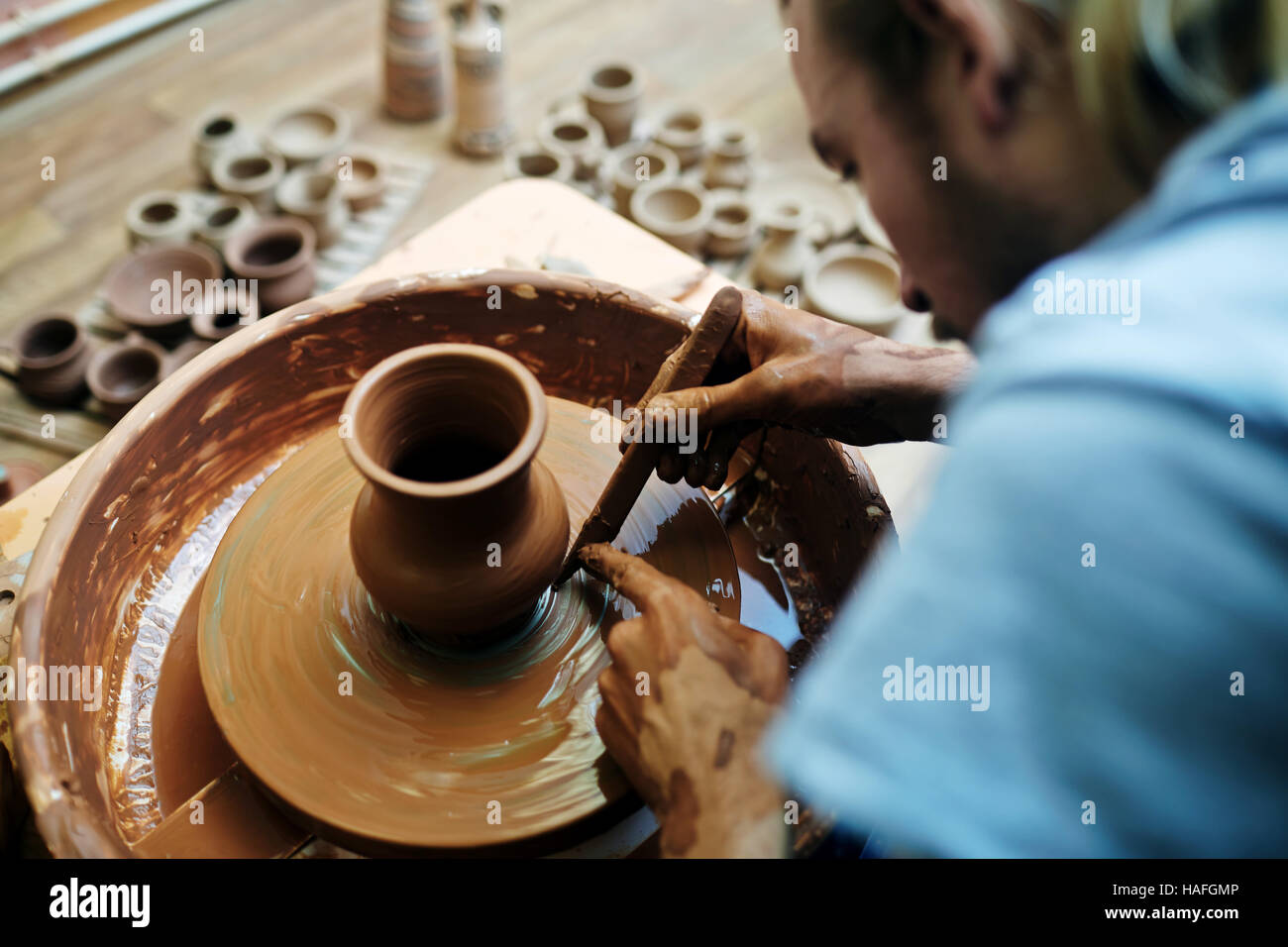 Lavoratori autonomi potter utilizzando lo strumento speciale durante la messa a punto di argilla Foto Stock