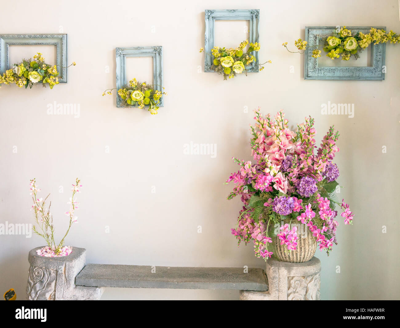 Rosa e viola bouquet di fiori in un vaso sul muro bianco Foto Stock