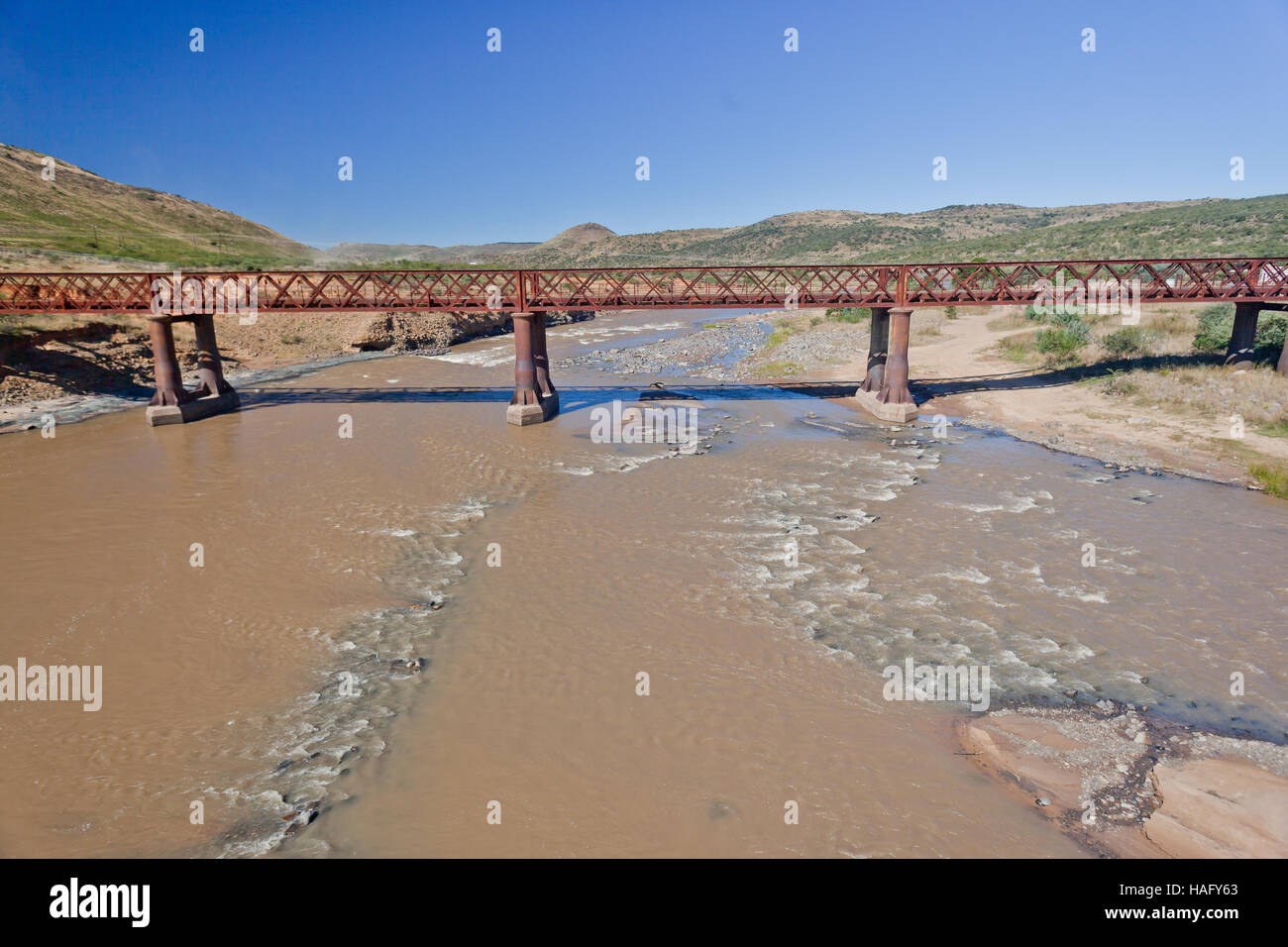 Ponte vecchio metallo acciaio singola corsia struttura sopra le acque del fiume in un paesaggio rurale. Foto Stock