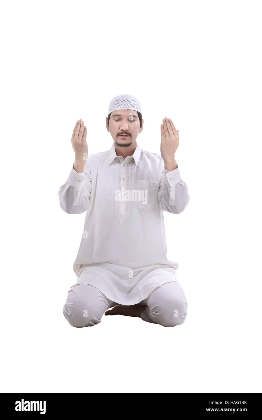 Giovani Musulmani uomo che prega isolate su sfondo bianco Foto Stock