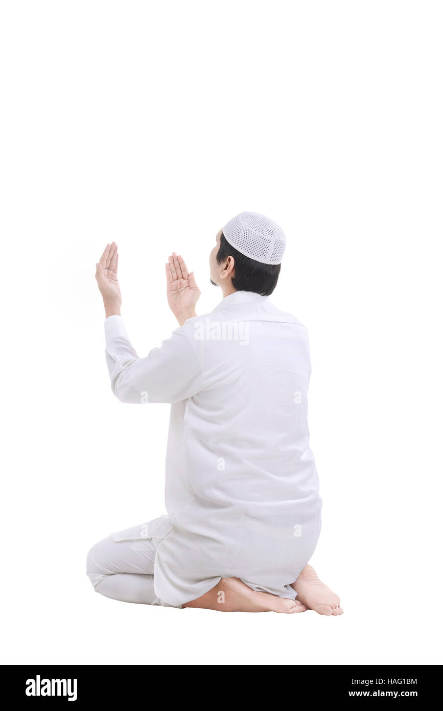 Giovani Musulmani uomo che prega isolate su sfondo bianco Foto Stock