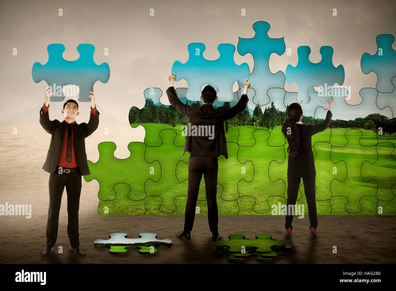 Lavoro di squadra aziendale assemblaggio di pezzi di un puzzle creare environtment verde. Industria verde concept Foto Stock