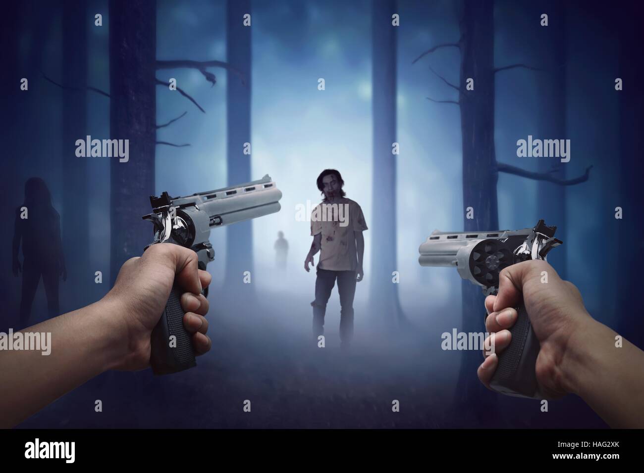 Man mano che regge due pistola e pronta per le riprese camminando zombie per lui Foto Stock