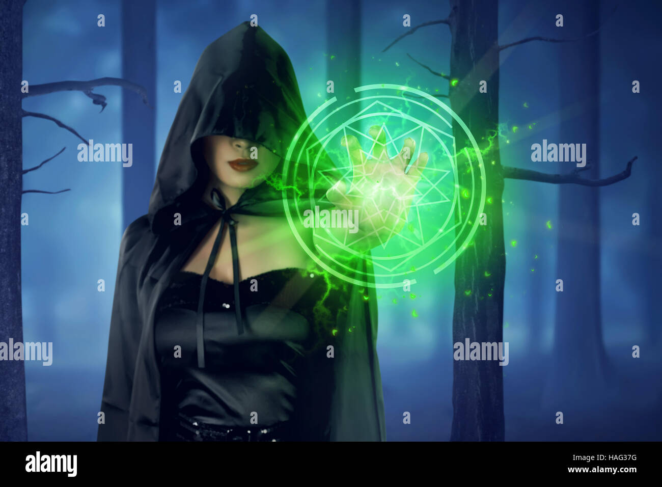 Asian strega donna con mantello di colore verde pentacolo dalla sua mano sulla foresta Foto Stock