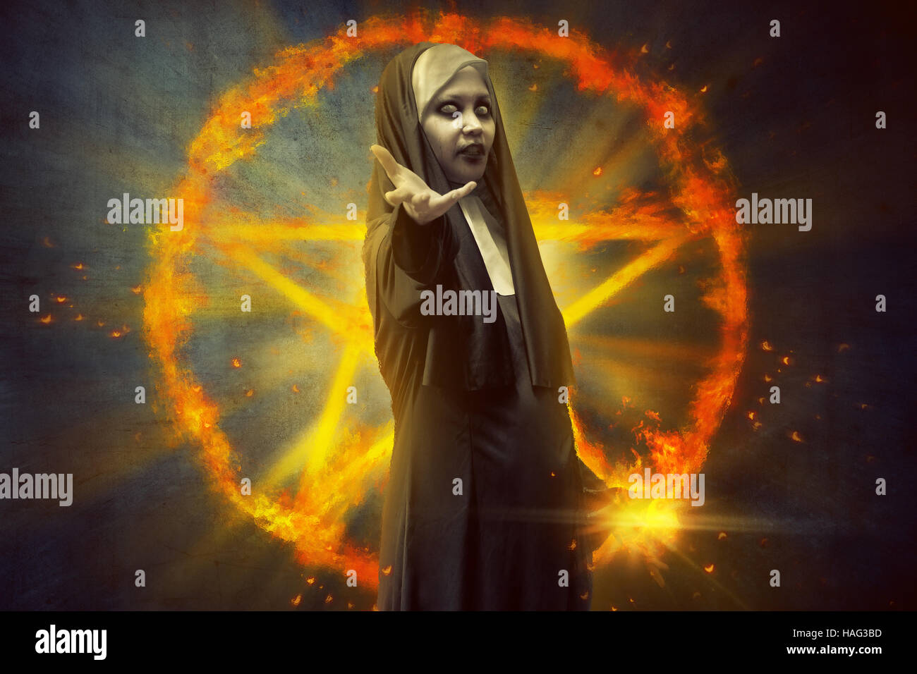 Diavolo nun donna in piedi di fronte a bruciare pentagram con magic spell in mano Foto Stock