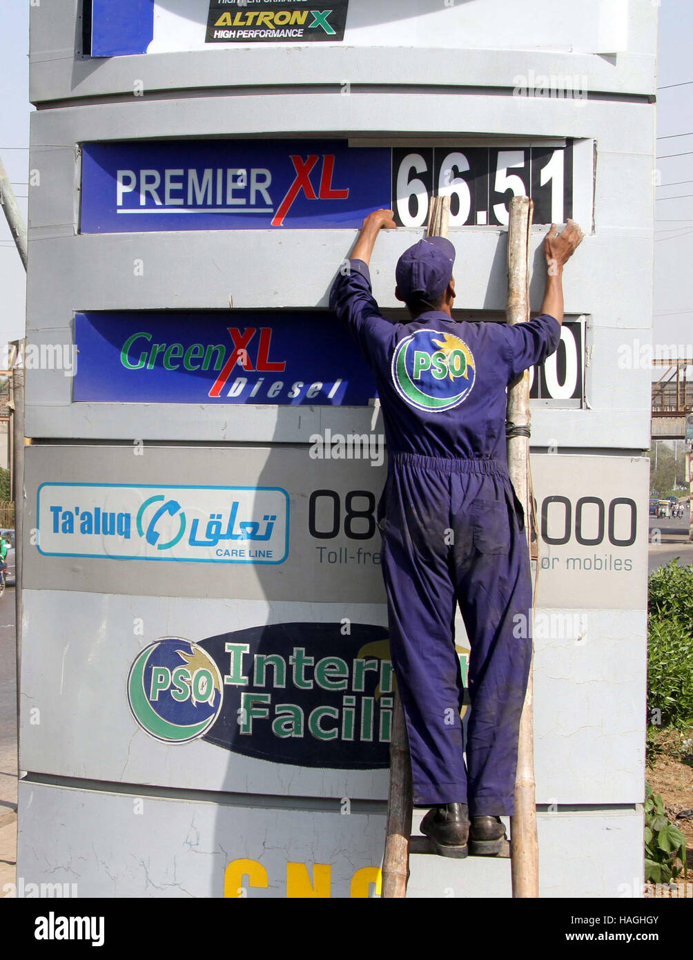 Pompa del carburante impiegato cambiando i prezzi del carburante dopo aumenti dei prezzi sui prodotti petroliferi, a Karachi il giovedì, 01 dicembre 2016. Olio e Gas Regulatory Authority (Ogra) aveva proposto un aumento di Rs6.24 nel prezzo della benzina; tuttavia, il prezzo potrà essere aumentata solo da Rs2. Foto Stock