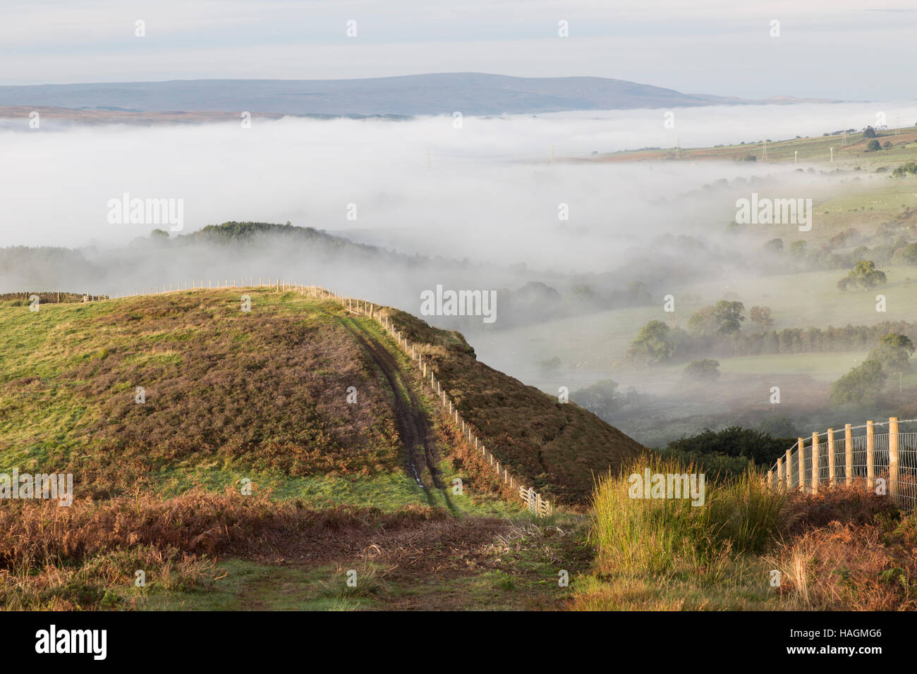 La vista dalla collina Barcombe, affacciato Vindolanda Roman Fort, con basse mist aggrappati a sud Tyne valle al di là Foto Stock