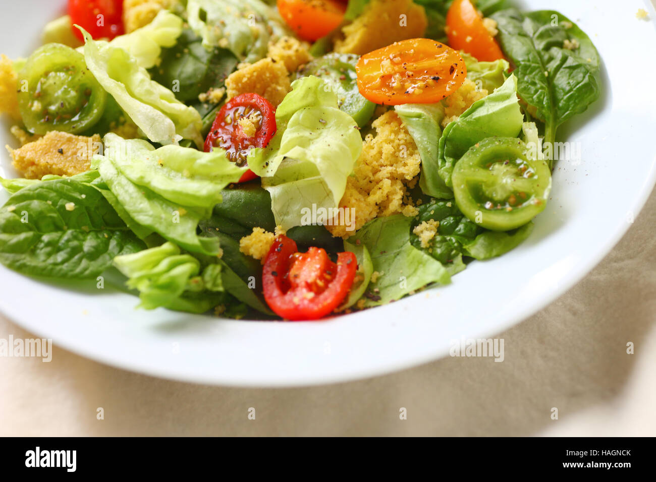 Primo piano del burro lattuga e insalata di spinaci con cornbread sbriciolato Foto Stock