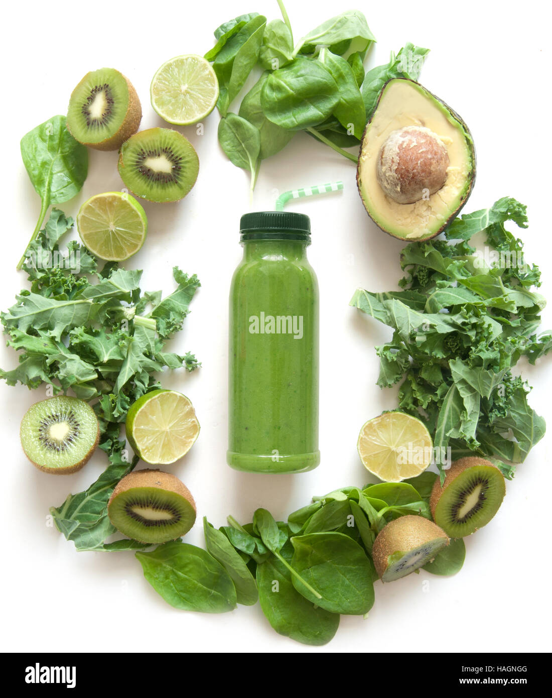 Imbottigliato frullato verde circondato con frutta e verdura compresi gli spinaci kale e avocado Foto Stock
