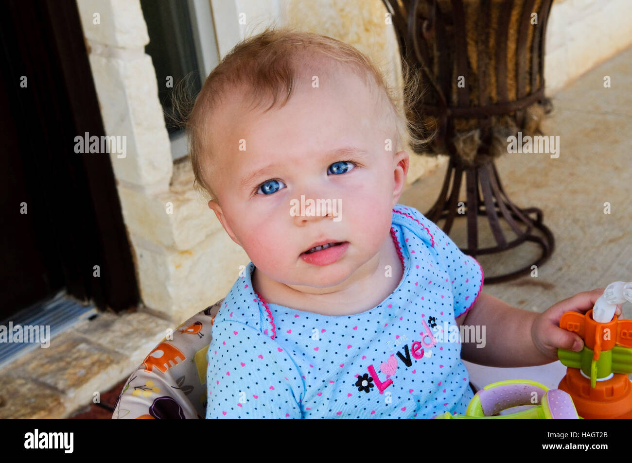 Close-up di Sweet Baby girl seduto in poltrona guardando la fotocamera Foto Stock