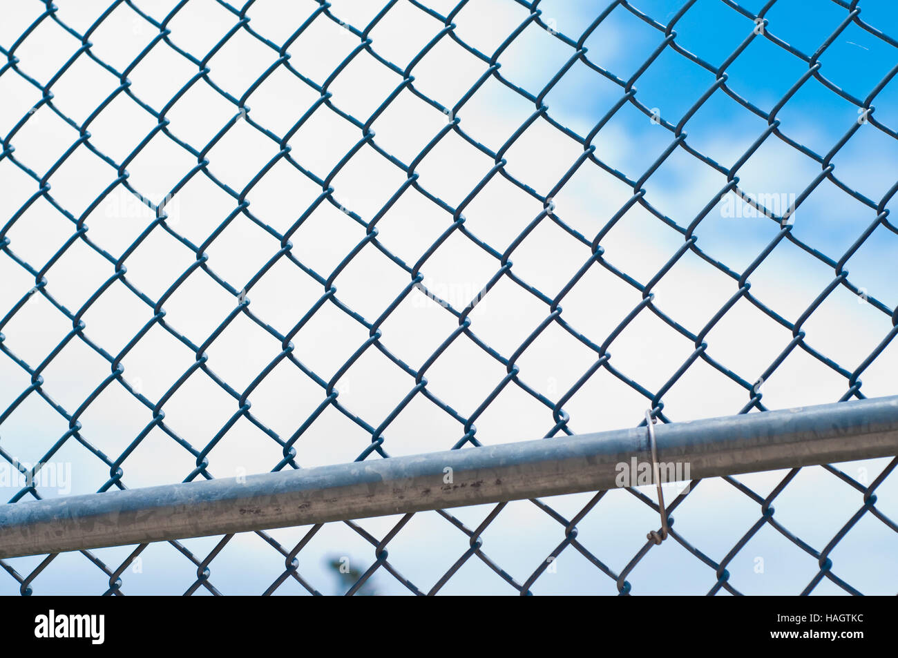 Il baseball catena collegamento recinto con cielo blu e nuvole bianche in background. Foto Stock