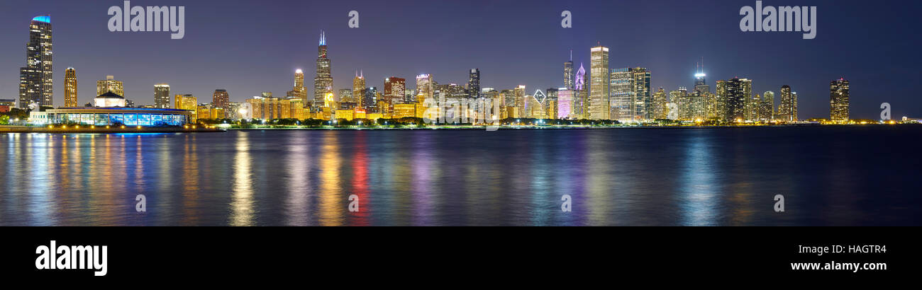Notte foto panoramiche di Chicago skyline della città con la riflessione nel lago Michigan. Foto Stock
