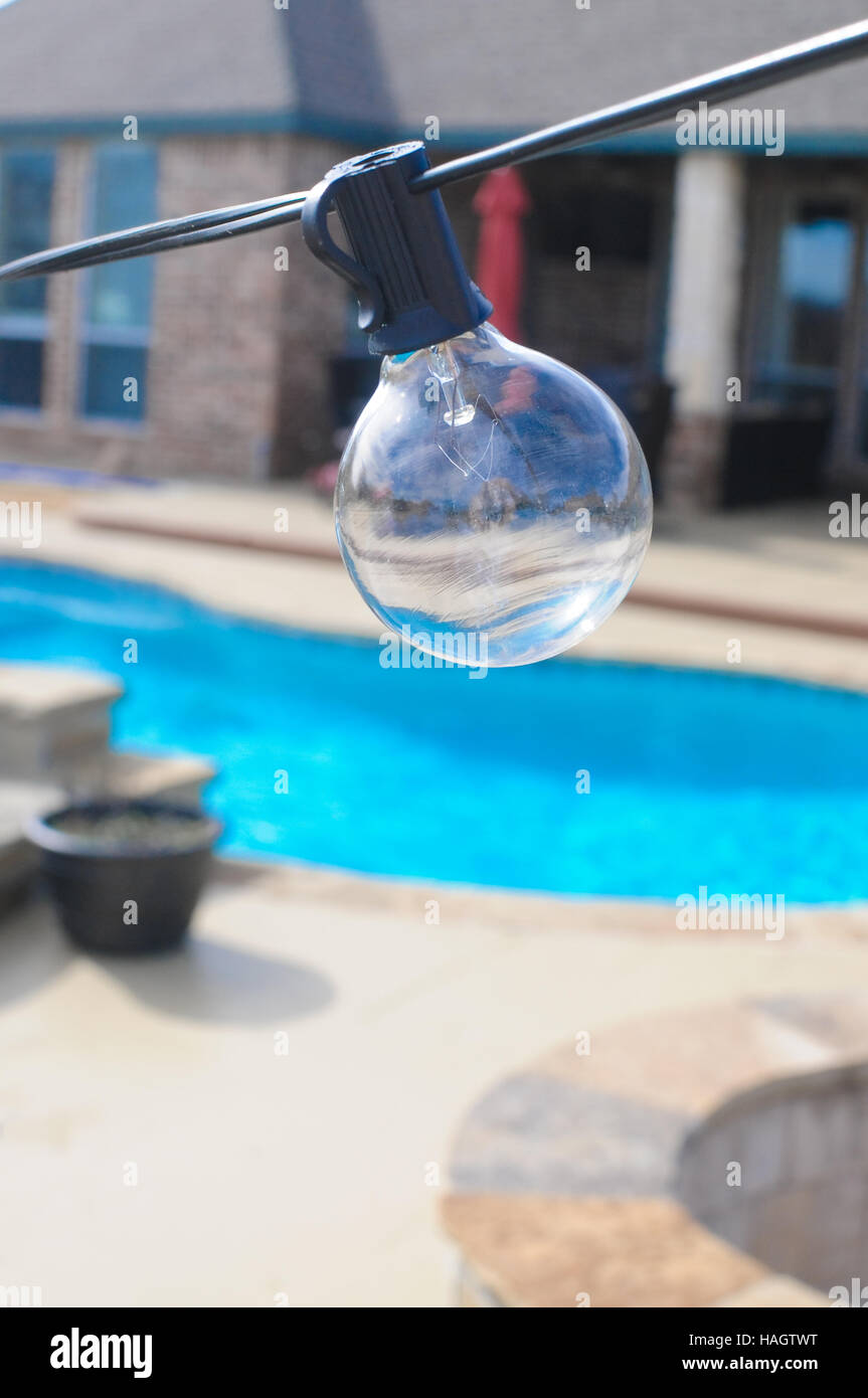 Una stringa lampadina all'aperto in cortile con piscina in background Foto Stock