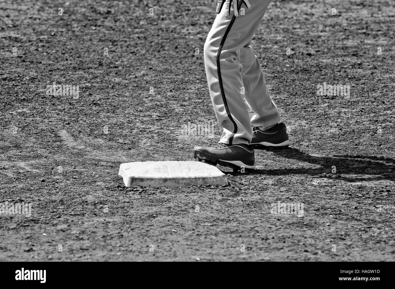 Chiudere fino in bianco e nero di base di baseball con il giocatore in piedi su di esso. Foto Stock