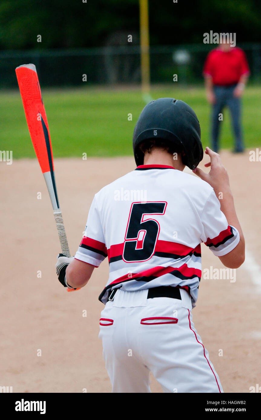 Specchietto di close-up di giovani giocatori di baseball afferrando il casco. Foto Stock