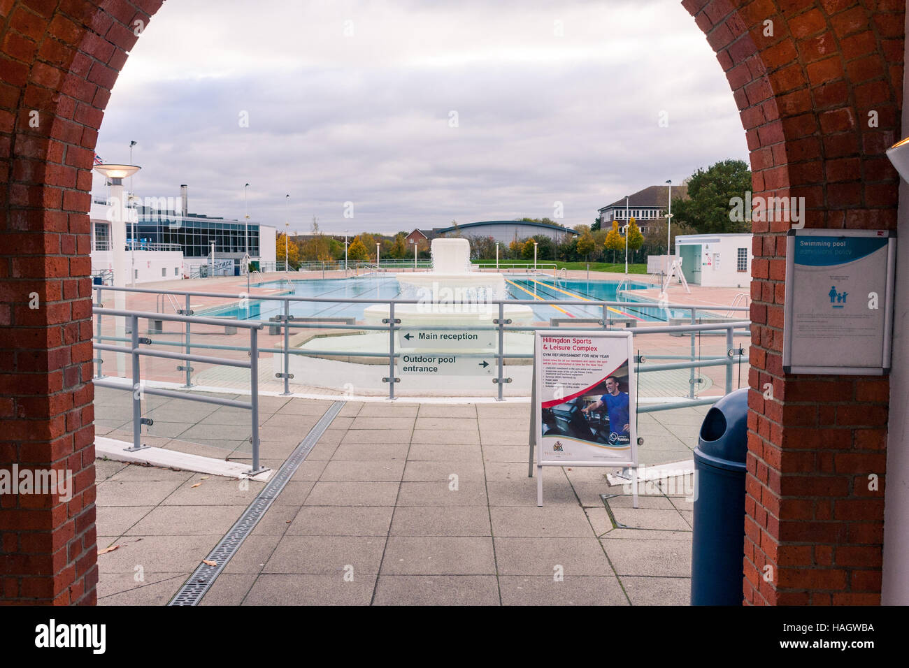 Vista della piscina esterna attraverso archway a Hillingdon Sport & tempo libero complessa, Hillingdon, Greater London, Regno Unito Foto Stock
