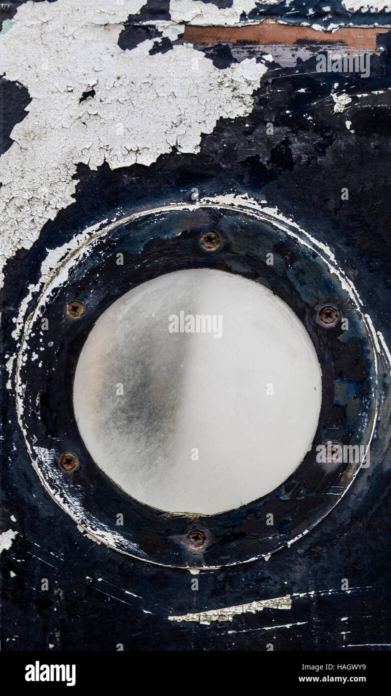 Oblò rotondo su una piccola barca abbandonata Foto Stock