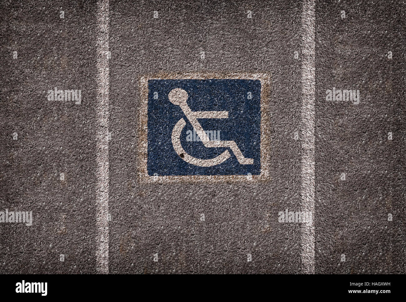 Sedia a rotelle il simbolo di parcheggio su asfalto parcheggio auto Foto Stock