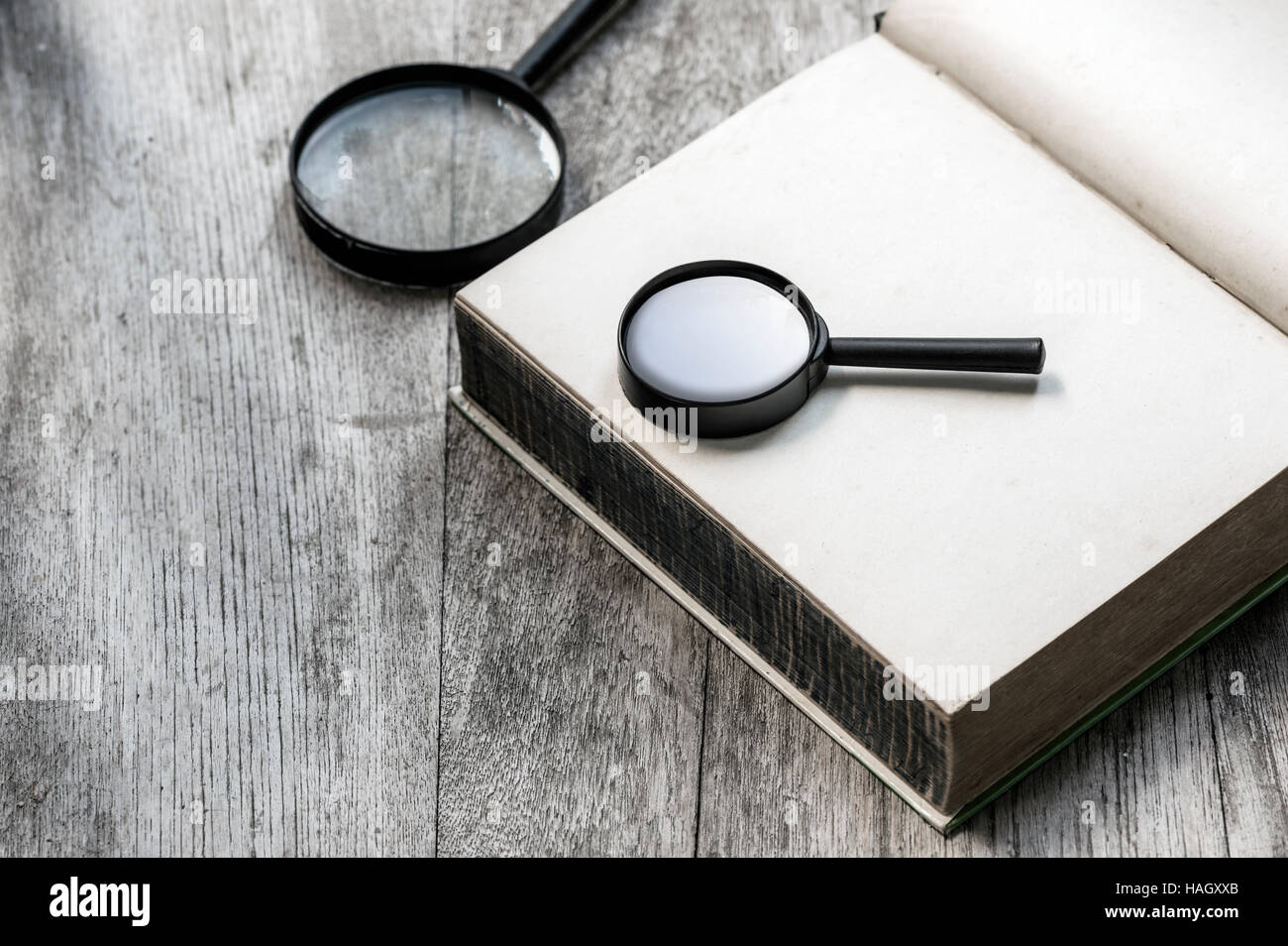 Lente di ingrandimento di vuoto sul notebook su uno sfondo di legno. Foto Stock