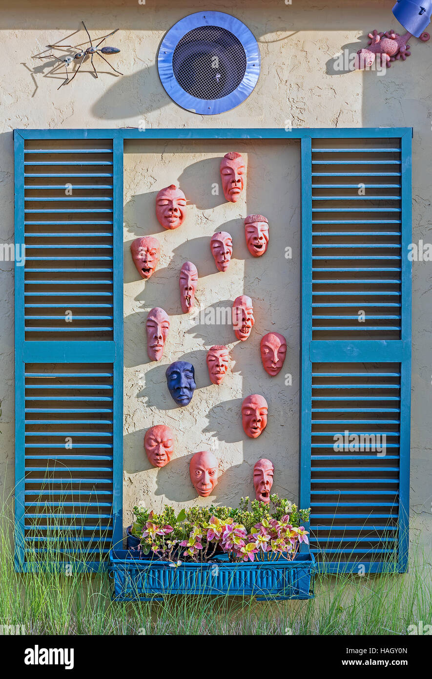 Telaio in legno di volto umano scultura in argilla in emozioni contrastanti sulla parete Foto Stock