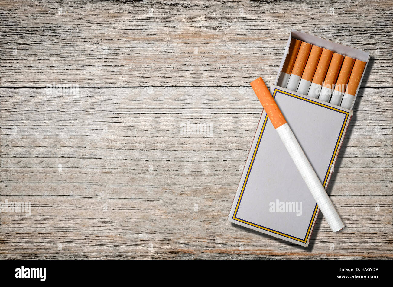 Sigarette nella casella di confronto su sfondo di legno. Foto Stock