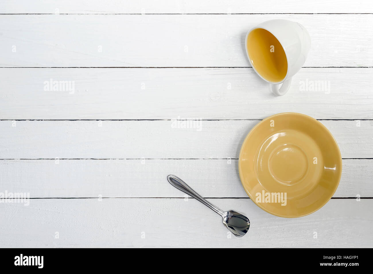 Tazza vuota, piattino e cucchiaio su sfondo di legno,vista dall'alto. Foto Stock