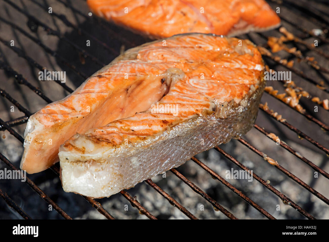 Salmone alla griglia bistecca di pesce Farina di barbecue per la cottura, preparato sulla griglia per il barbecue, close up Foto Stock