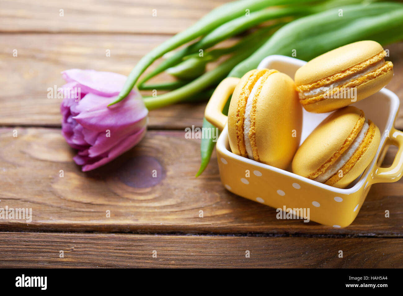 Gli amaretti e viola tulip sul tavolo di legno Foto Stock