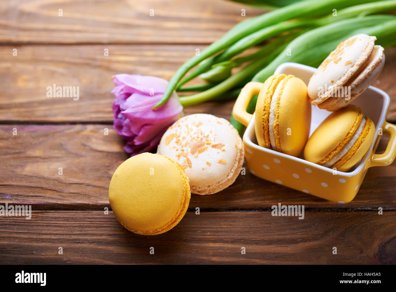 Gli amaretti e viola tulip sul tavolo di legno Foto Stock