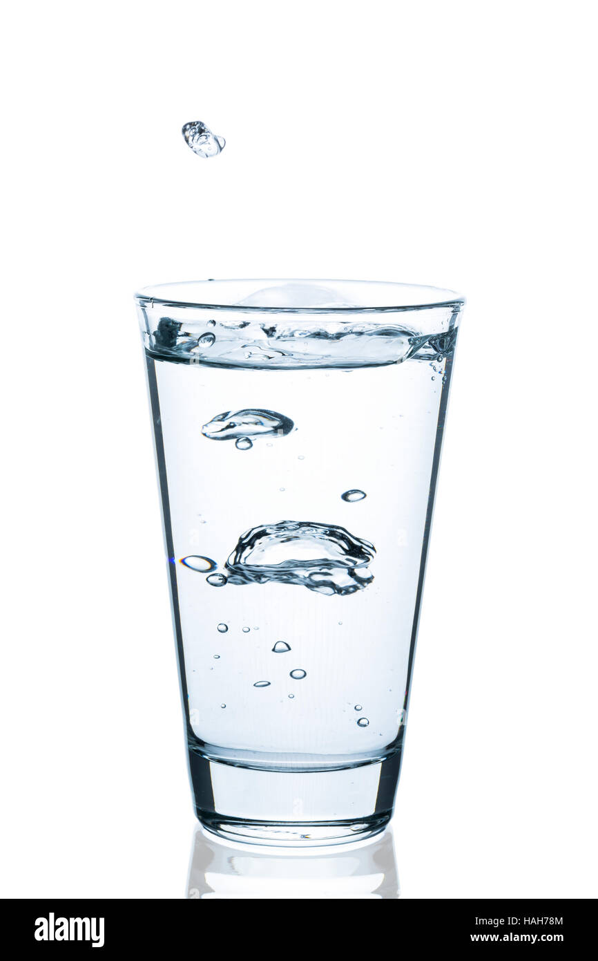 Bicchiere di spruzzi d'acqua con gocce isolati su sfondo bianco Foto Stock