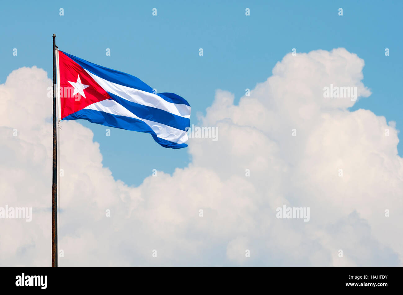 Bandiera cubana in volo da un pennone al vento nella parte anteriore del drammatico le nuvole in Havana, Cuba Foto Stock