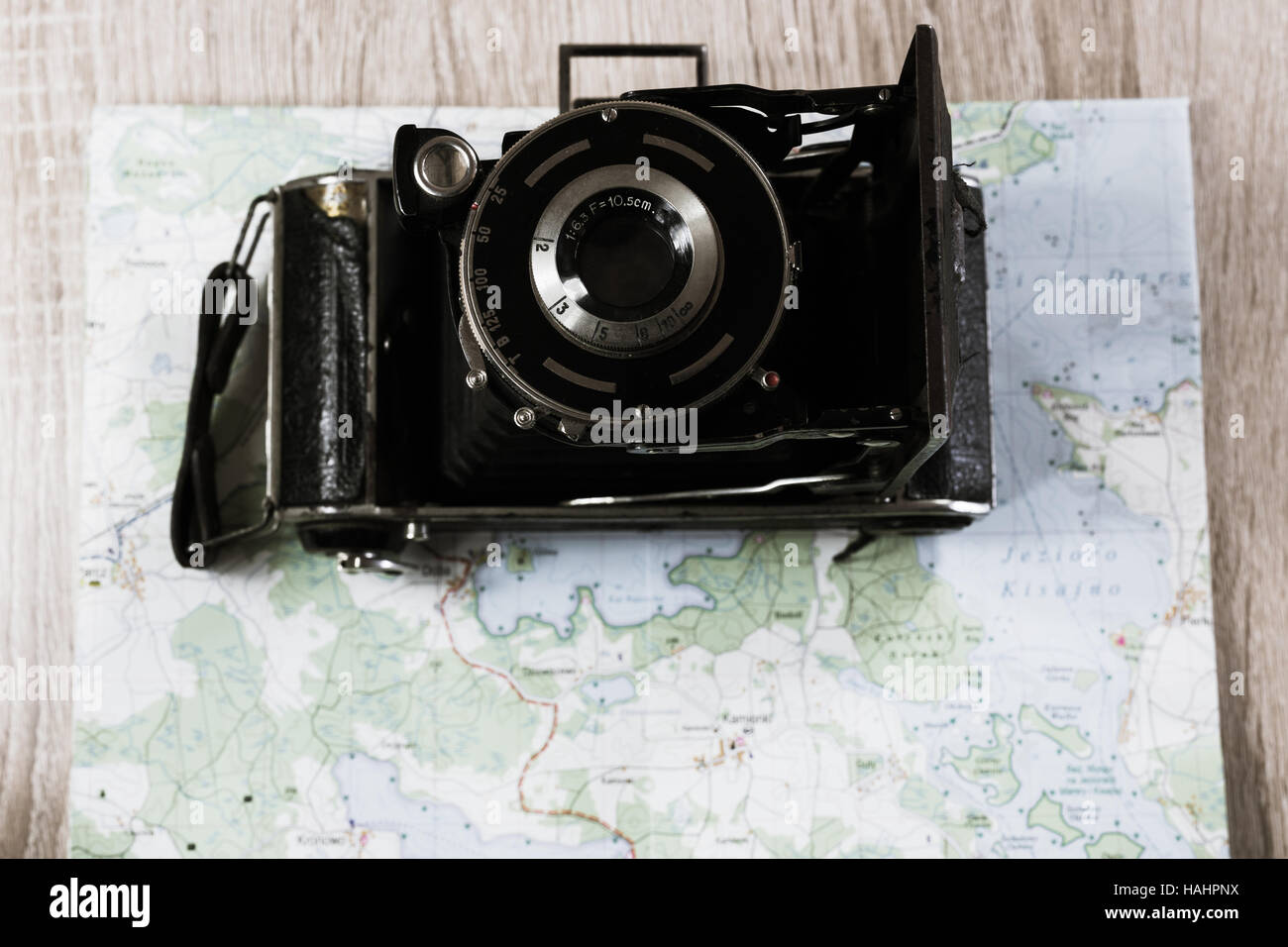 Vecchio piegato Leica fotocamera con lente prontor su una mappa di laghi in Polonia. Fotocamera obsoleta su una mappa. Foto Stock