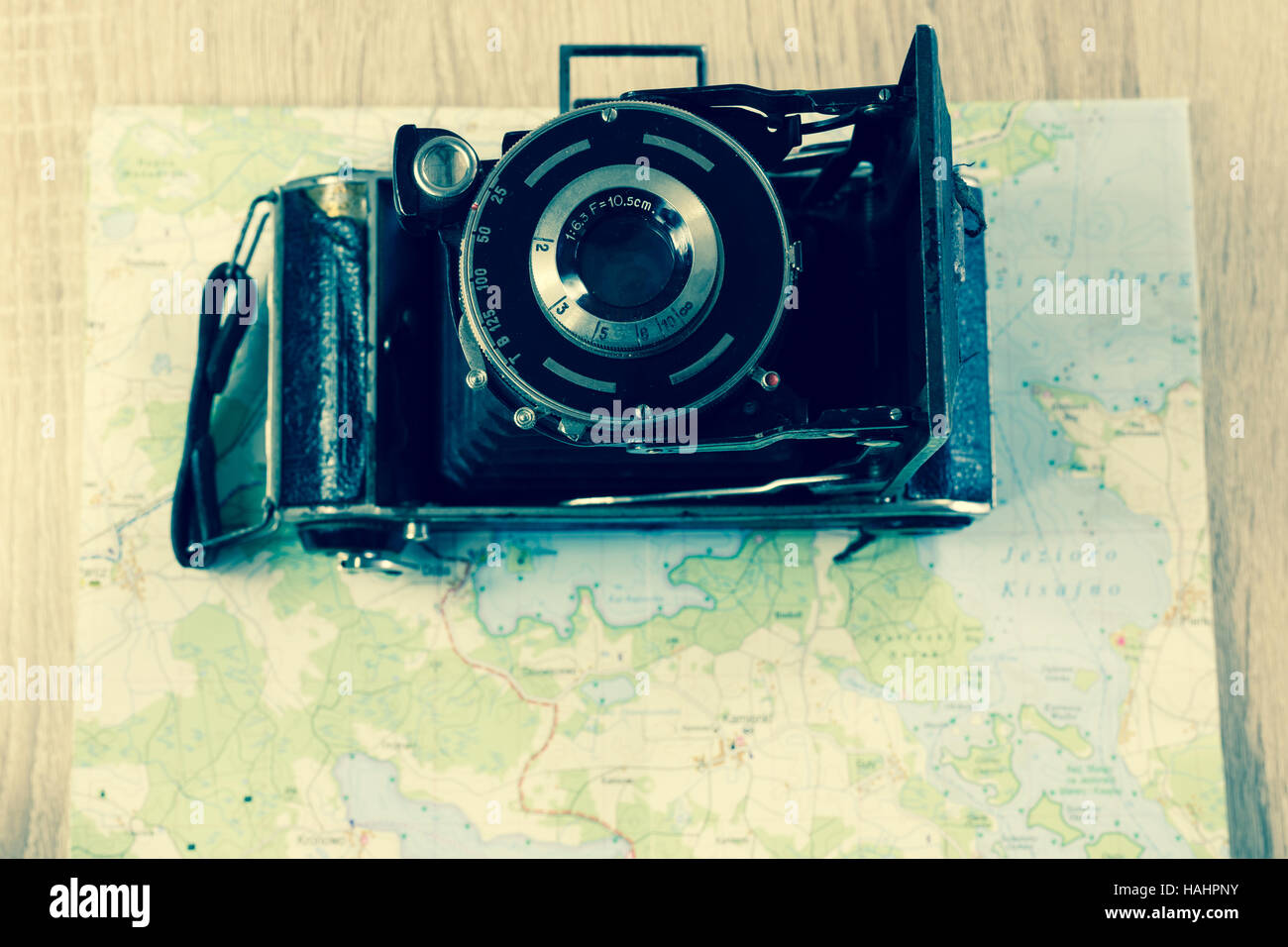 Vecchio piegato Leica fotocamera con lente prontor su una mappa di laghi in Polonia. Fotocamera obsoleta su una mappa. Foto Stock
