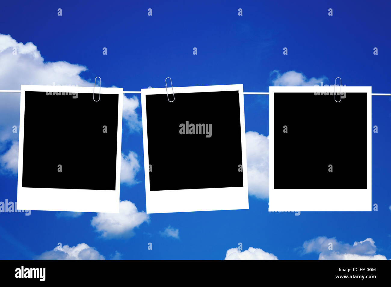 Tre blank foto quadri appesi sulla linea contro il cielo blu Foto Stock
