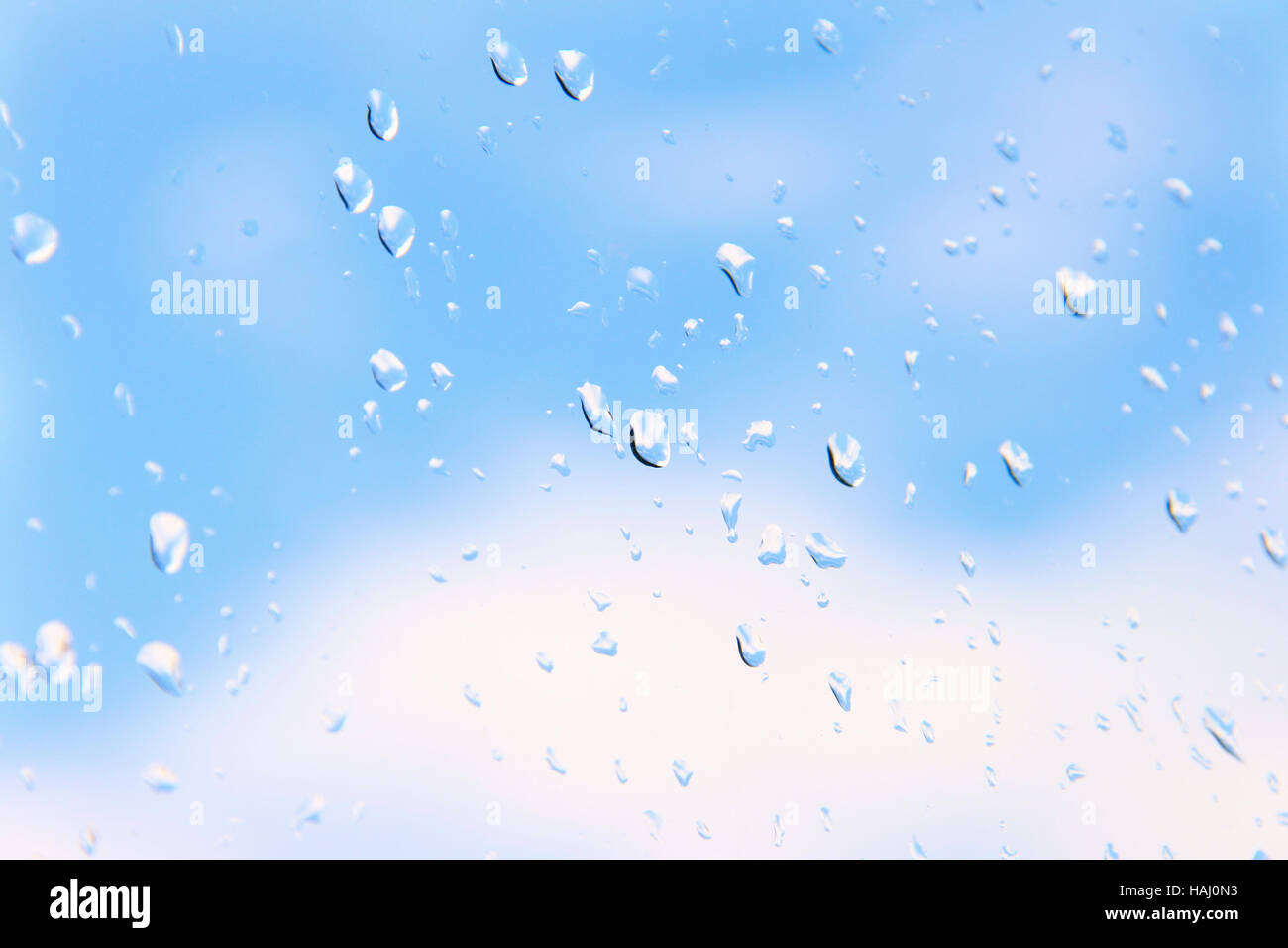 Gocce di acqua su vetro contro il cielo blu Foto Stock