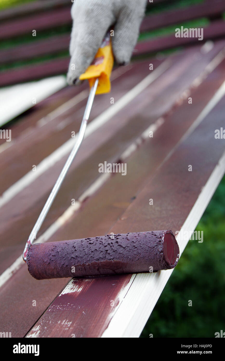 Pittura tavolato in legno con rullo a colori Foto Stock