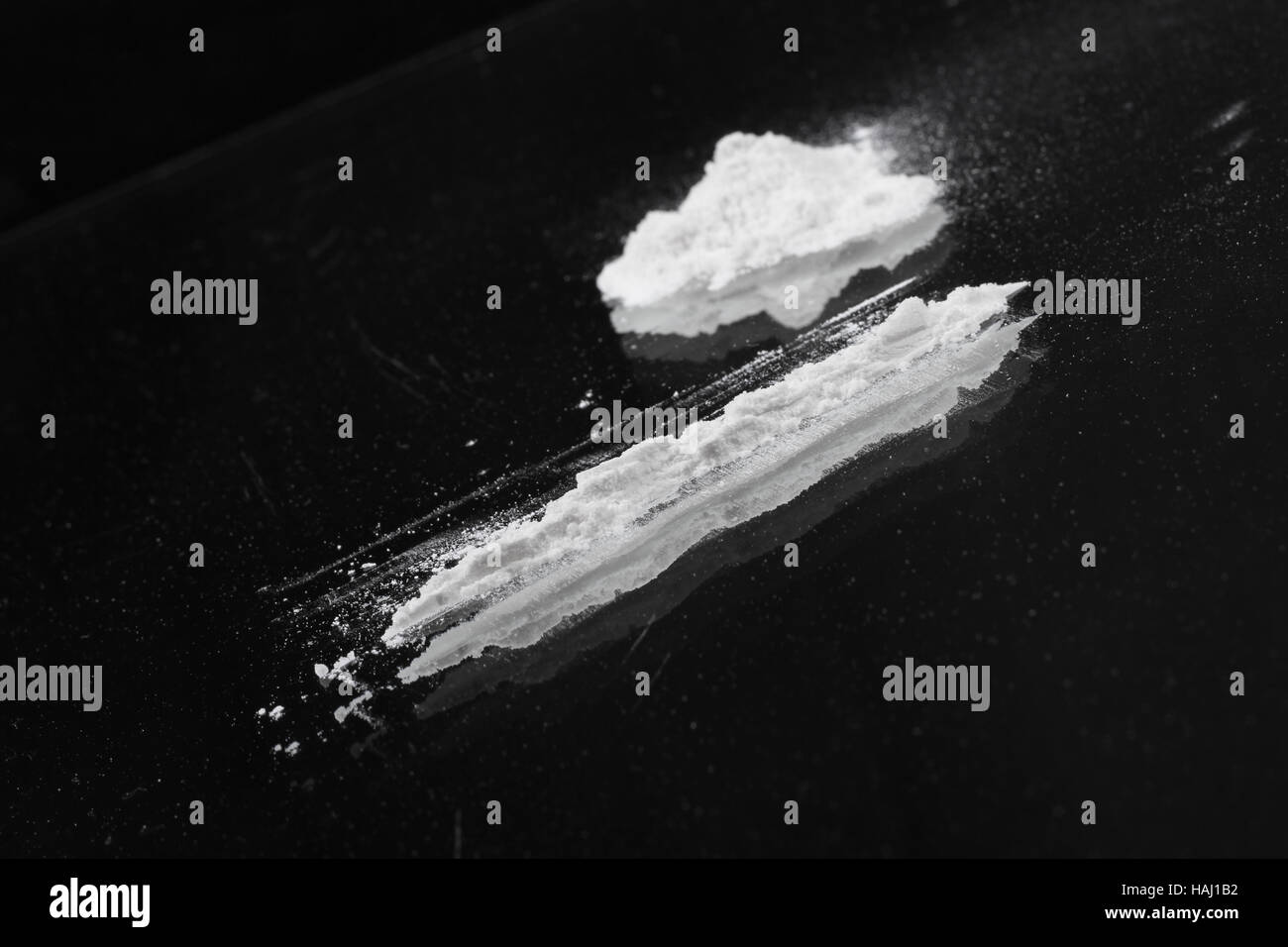 Linea di cocaina e heap su nero Foto Stock