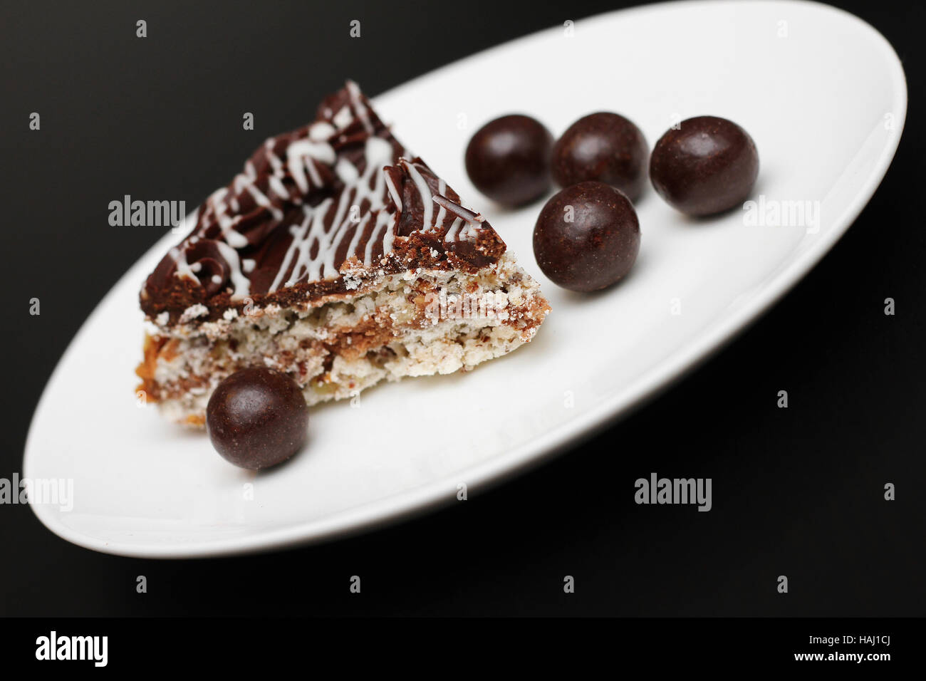 La torta su un piatto con i dadi nel cioccolato Foto Stock