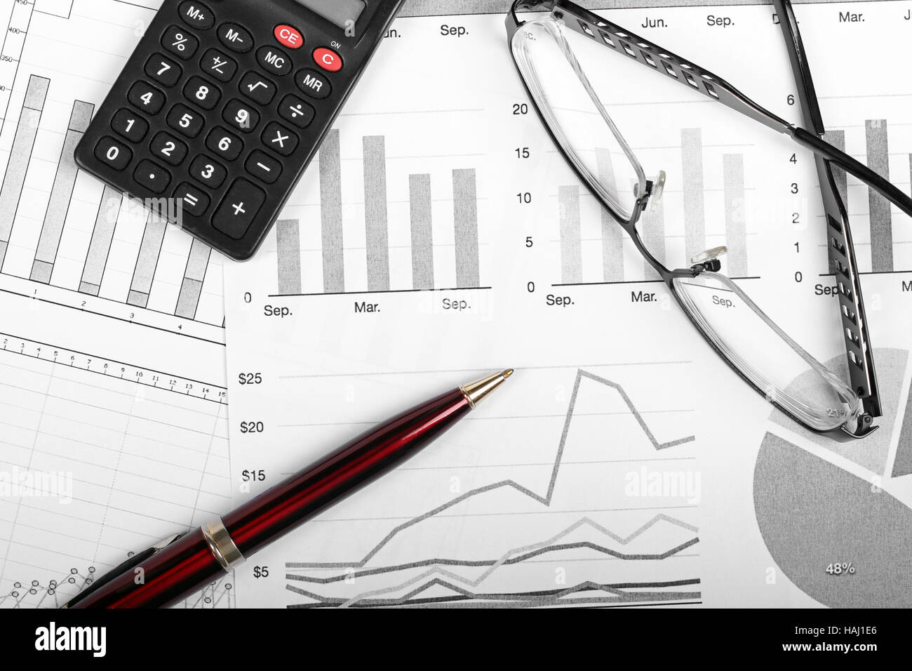 Finanza aziendale grafici con penna, bicchieri e calcolatrice Foto Stock