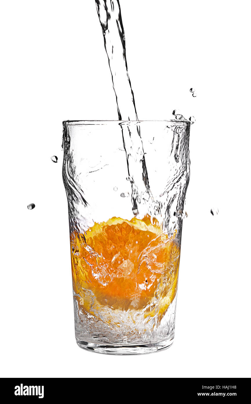 Versare acqua in vetro con fetta di arancia su bianco Foto Stock