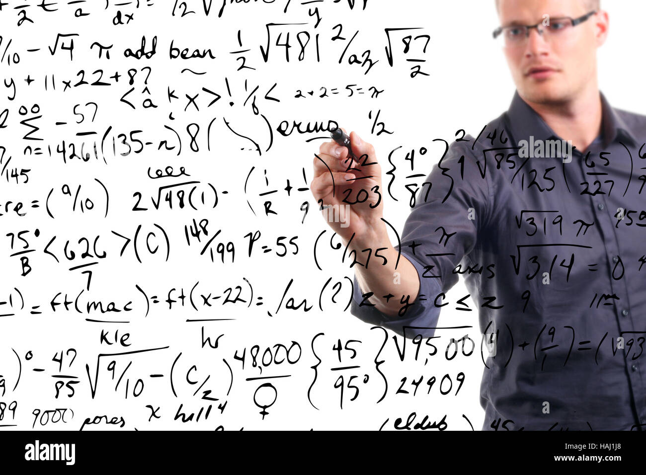 Uomo scrive equazioni matematiche su whiteboard Foto Stock
