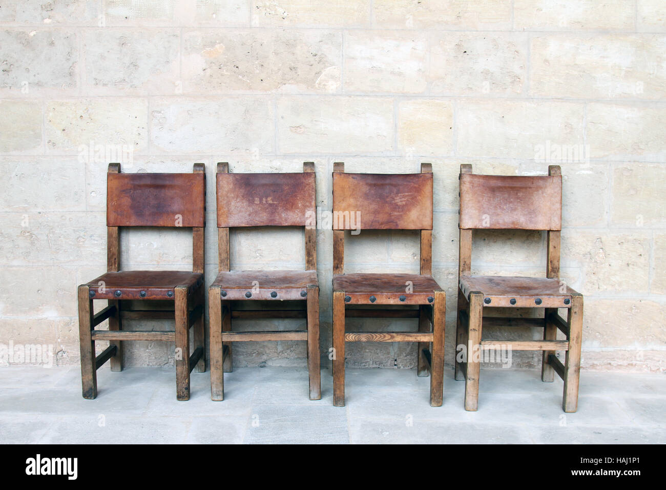 Quattro sedie vintage presso il muro di pietra Foto Stock