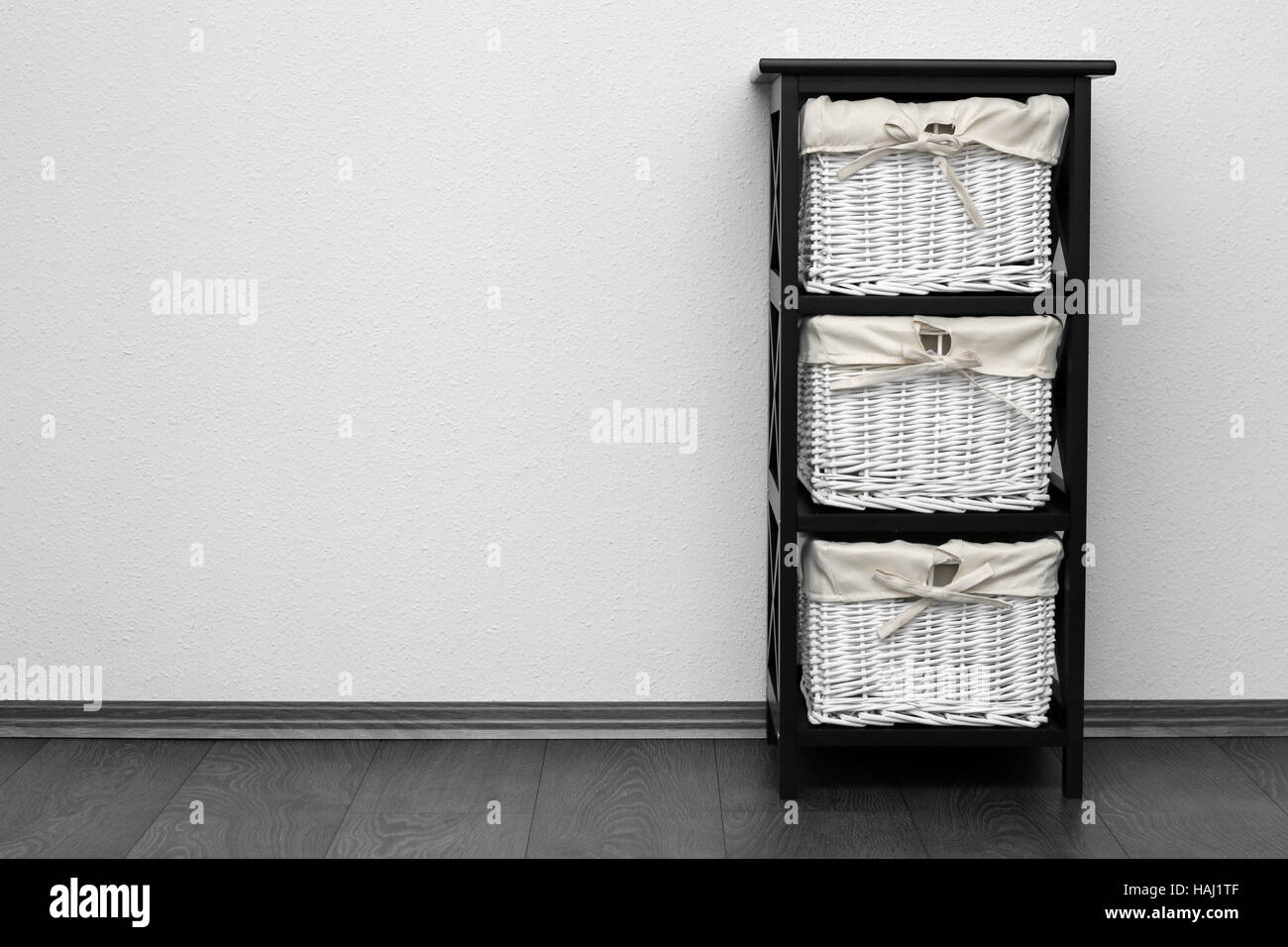 Ripiano marrone con cestini di vimini a muro bianco Foto Stock