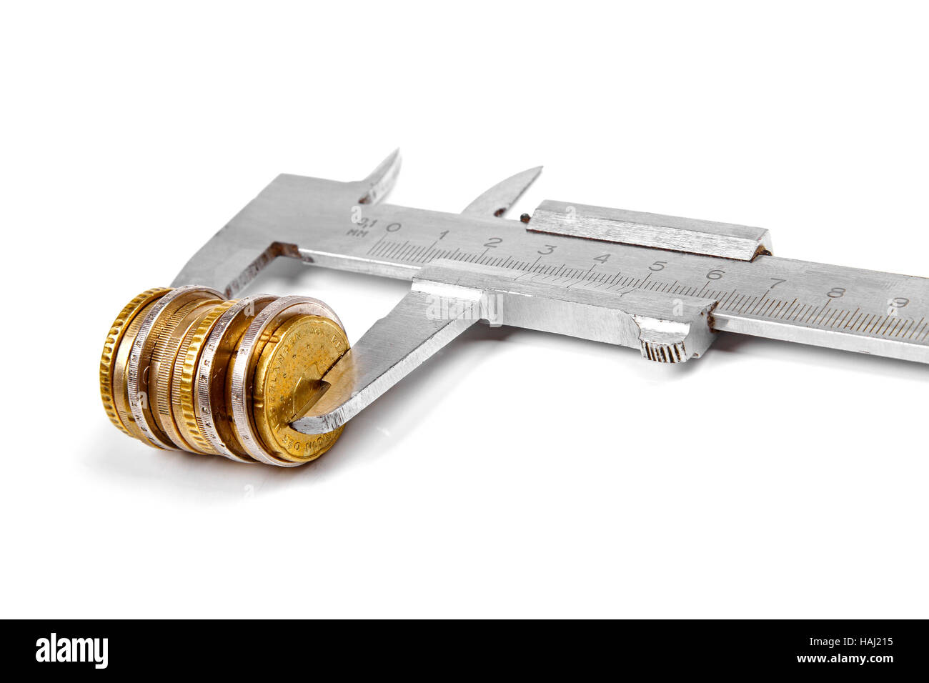 Il calibro e la pila di monete isolati su sfondo bianco Foto Stock