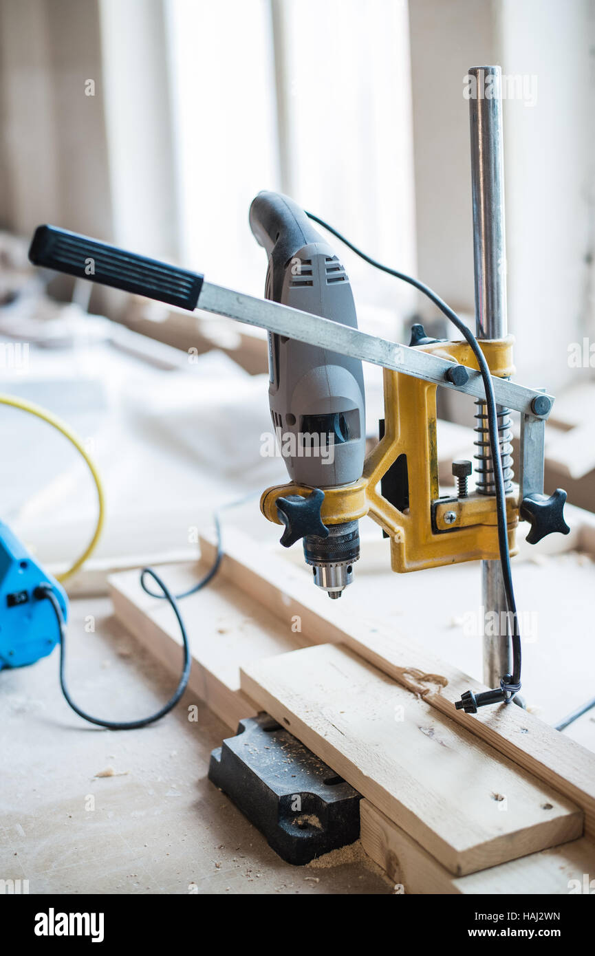La vite e il trapano elettrico sul legno in officina Foto Stock